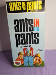 Box of the "Ants in the Pants" game featuring a cartoon image of two children playing with a pair of blue pants propelling red ants into the air, intended for ages 3 to 10.