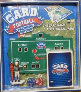 Sealed "Card Football Premiere Edition" game package with a miniature football field scoreboard, referee figure, dice, and playing cards visible through the packaging.