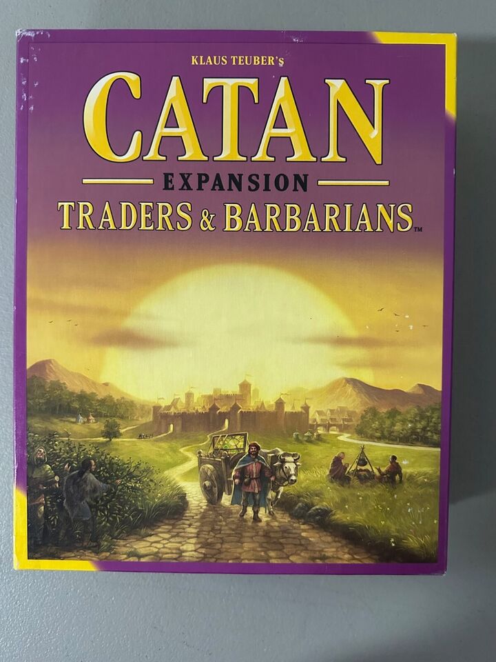 Box cover of "Klaus Teuber's Catan Expansion: Traders & Barbarians" board game, featuring illustrated medieval characters on a road leading to a fortified city.