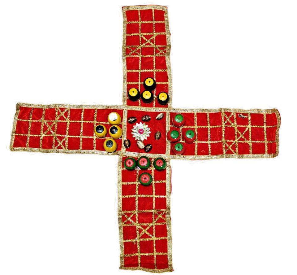 A handmade cross with a red fabric background embellished with a gold grid pattern and decorated with various colorful buttons and beads.
