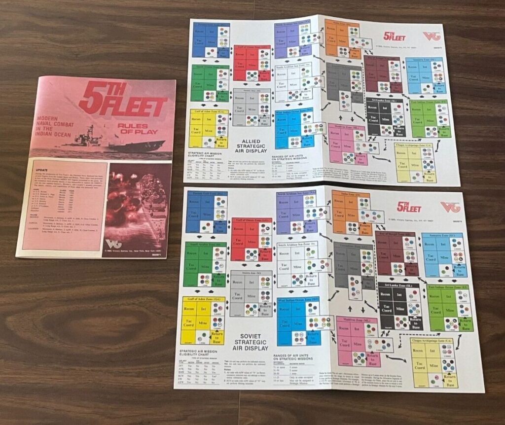 A "5th Fleet" board game laid out on a wooden surface, showing the rule book and two charts titled "ALLIED STRATEGIC AIR DISPLAY" and "SOVIET STRATEGIC AIR DISPLAY" with various colored boxes representing different unit types.