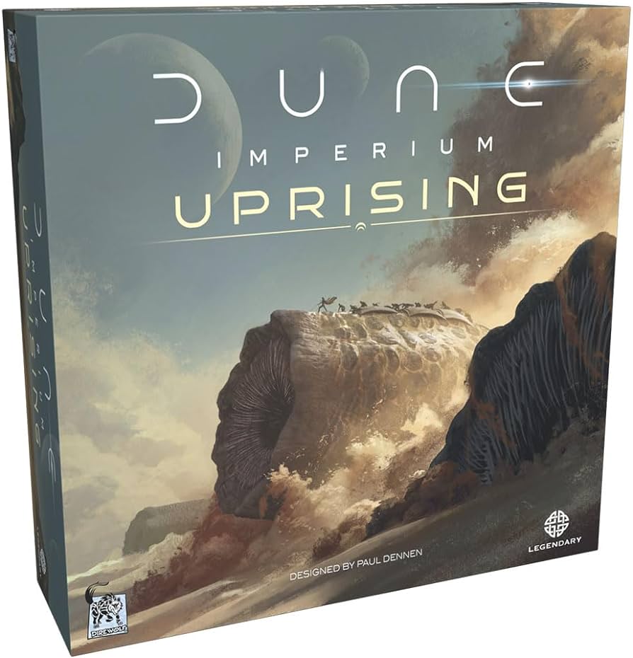 "Dune: Imperium Uprising" board game box with a large sandworm emerging from the sand and two moons in the sky.
